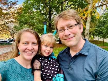 Naomi, dressed as a butterfly, held between her parents