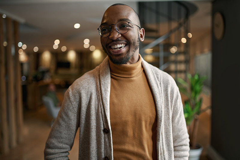 A cheerful man strolls through a beautifully designed home, enjoying the peaceful atmosphere.