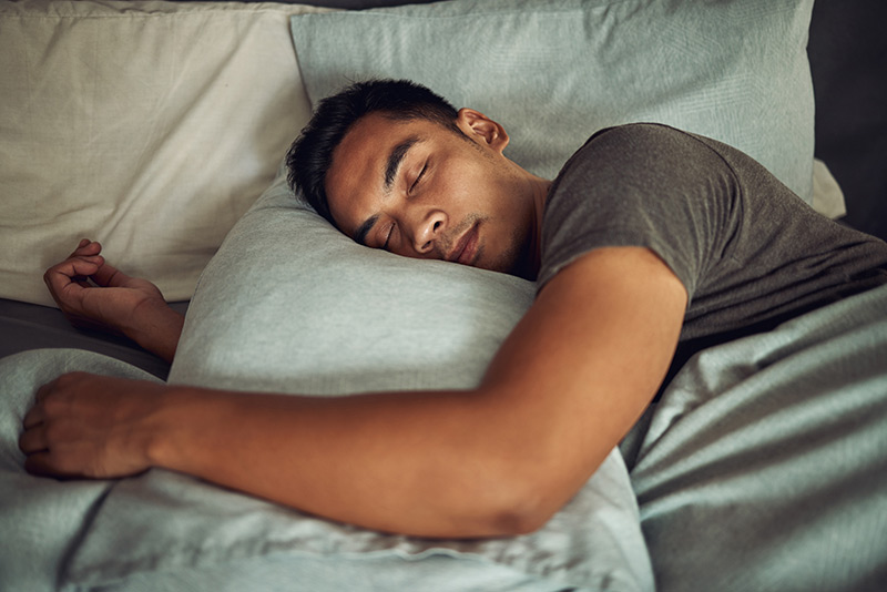 Man sleeping soundly with his head on a pillow.