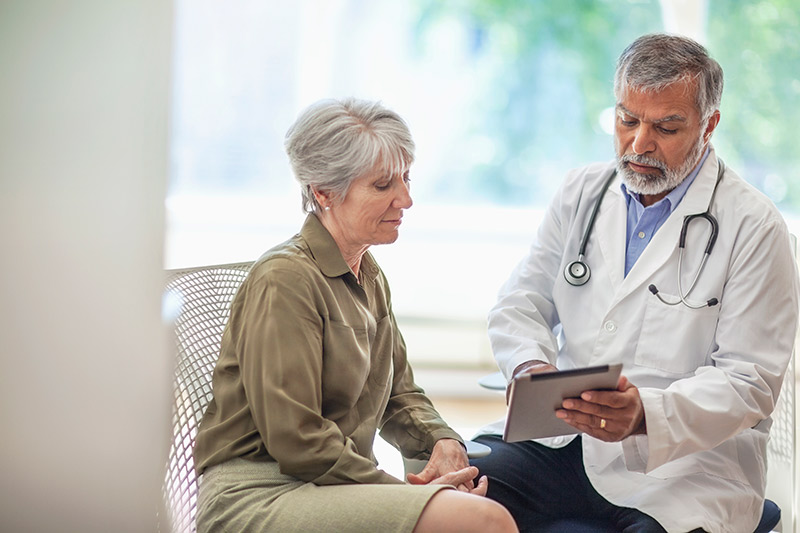 Ophthalmologist and patient seated across desk in clinic