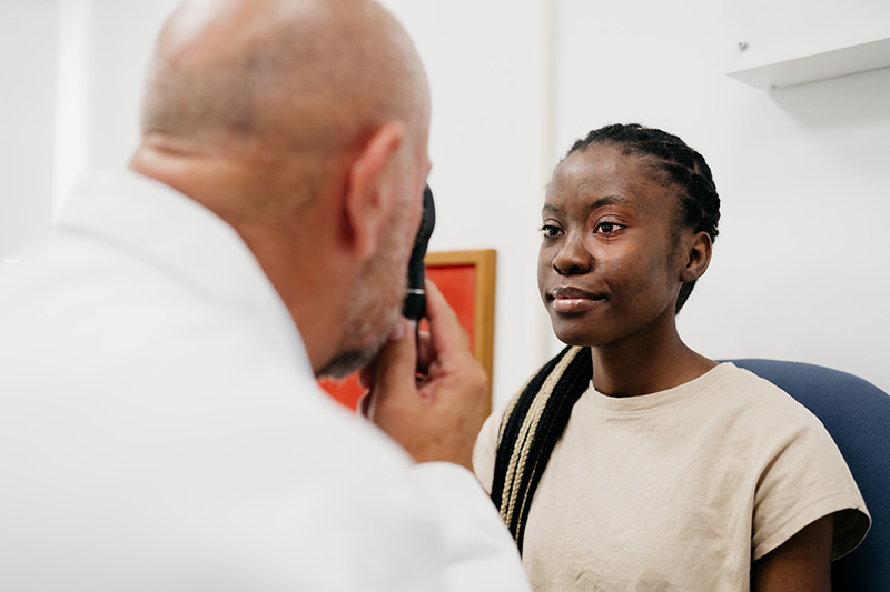 Eye specialist talking to patient inside vision care office