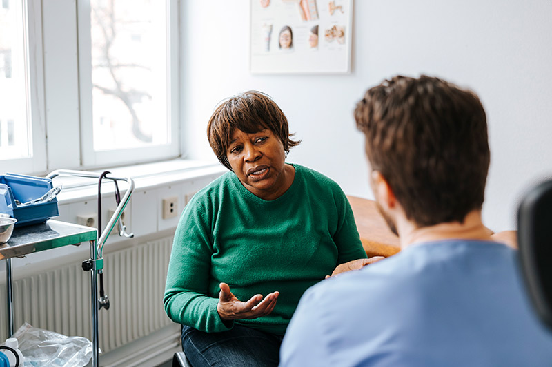 Eye specialist talking to patient inside vision care office