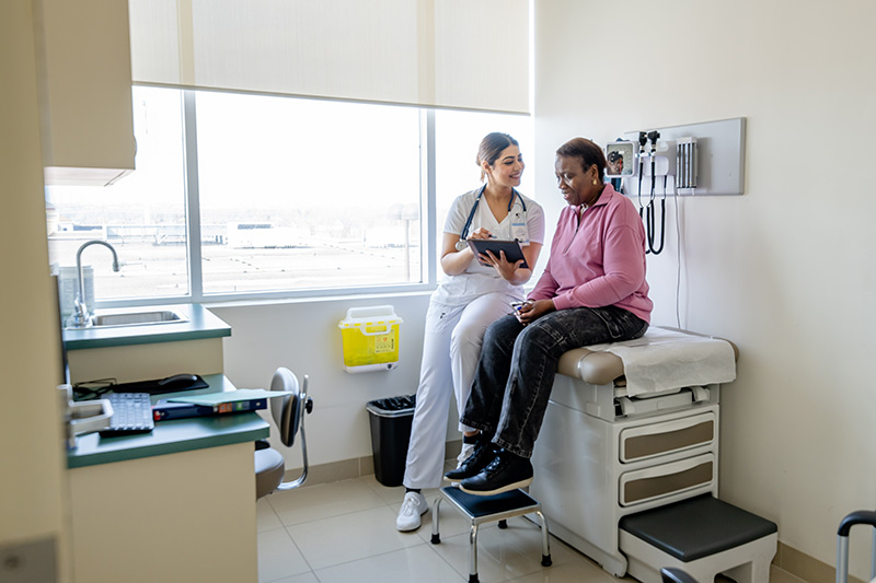 Eye specialist talking to patient inside vision care office