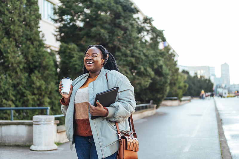 woman with coffee cup and iPad on the street