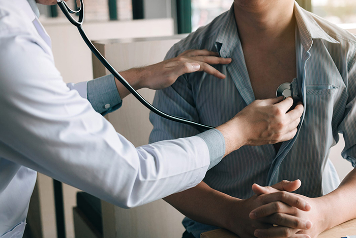 a doctor listens to a patient's heart beat
