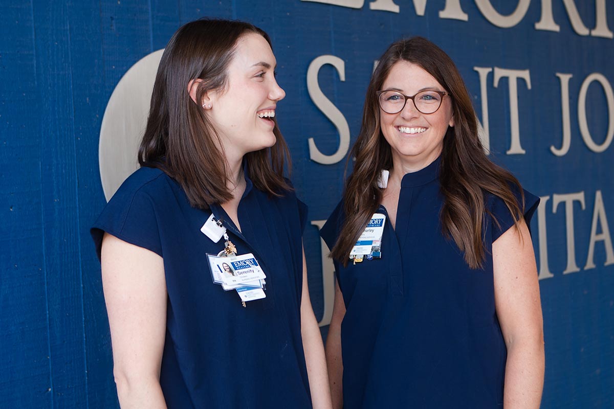 two emory nurses smile outside of emory st johns hospital