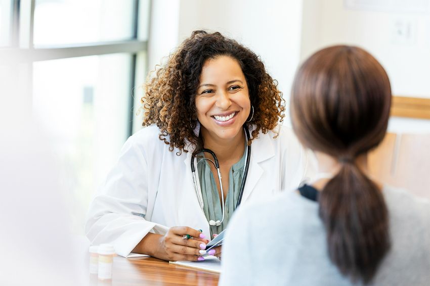 physician smiling while consulting patient