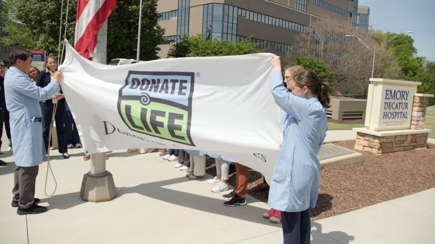 two people holding a Donate Life flag